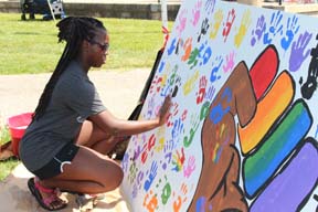 Girl adds handprint to sign 